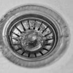 Drain cover in a sink, emphasizing plumbing maintenance and safety concerns related to clogged drains.