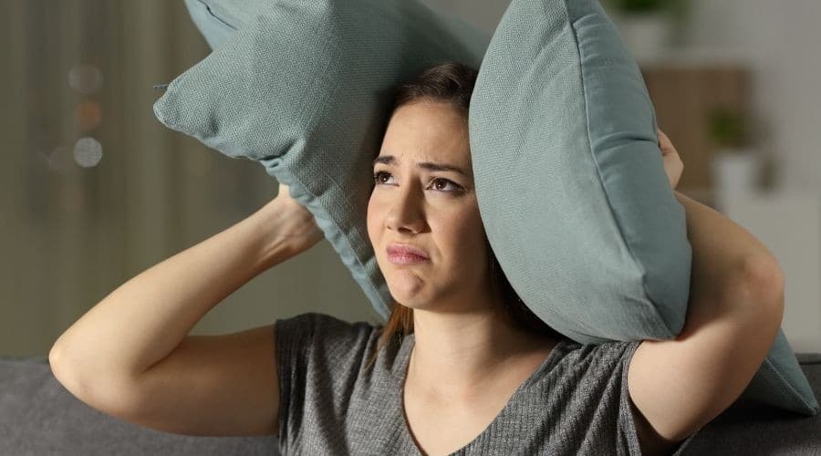 A woman on a couch with blue-gray pillows
