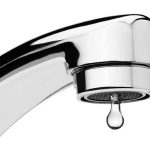 Close-up of a chrome touchless faucet with a water droplet forming at the spout, symbolizing plumbing upgrades for Father's Day and home improvement solutions.