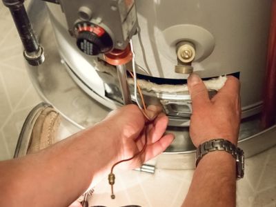 Technician performing maintenance on a commercial water heater, ensuring efficient operation and reducing risk of outages and damage.